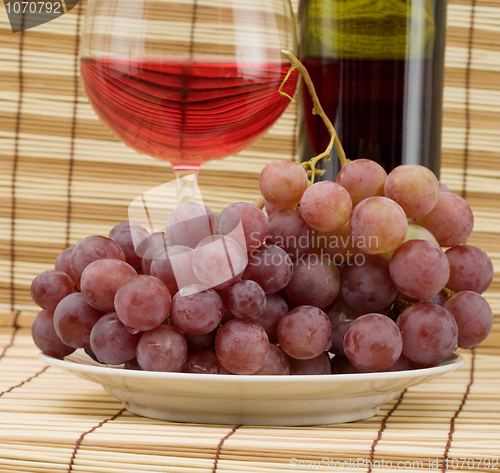 Image of Glass bottle, goblet and grape