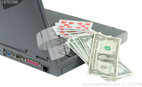 Image of Laptop, playing cards and dollars