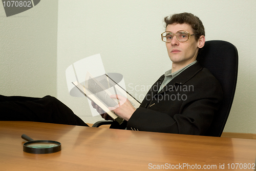 Image of Guy in eyeglasses reads the book