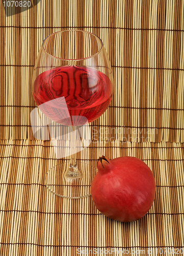 Image of Glass of wine and red pomegranate