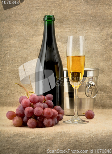 Image of Champagine bottle, grape and goblet on canvas background