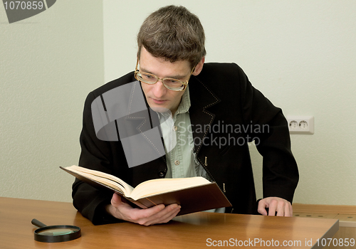 Image of Guy in eyeglasses reads the book