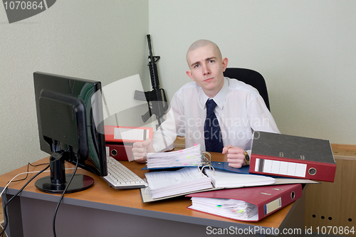 Image of Chief on a workplace with a rifle on a background