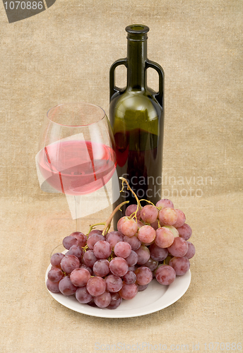 Image of Still-life with a glass of red wine, bottle and grapes