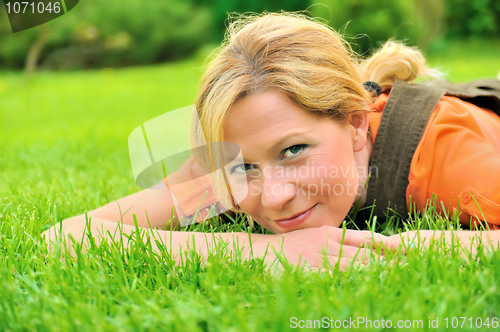 Image of Young woman relaxing on the grass
