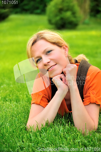 Image of Young woman relaxing on the grass