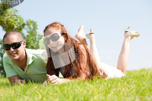 Image of beautiful young Couple lie down on grass