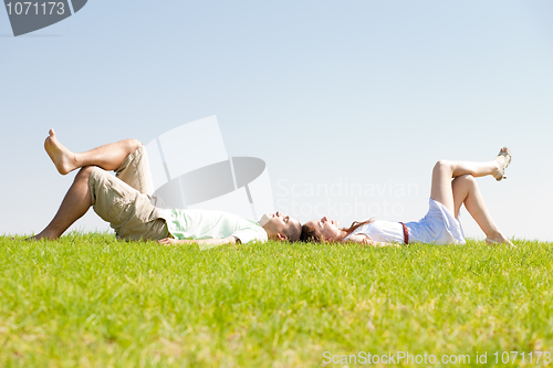 Image of couple lie down on grass