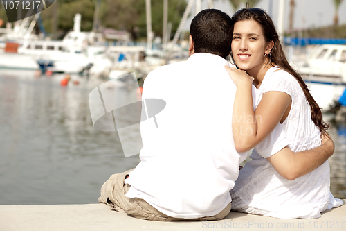 Image of Young Couple Seated and Hugging On A Footbridge