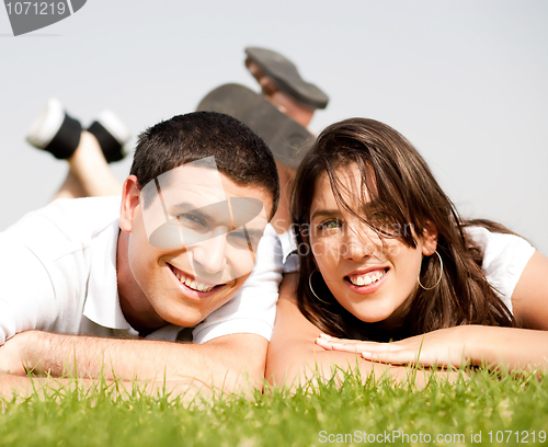 Image of happy young Couple lie down on grass