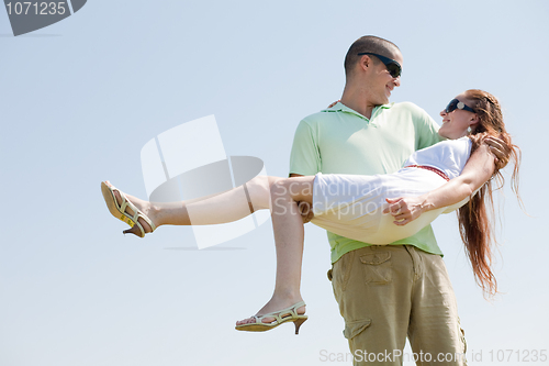 Image of Young Guy Carrying His Girlfriend In His Arms