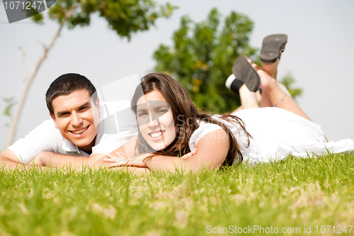 Image of beautiful young Couple lie down on grass