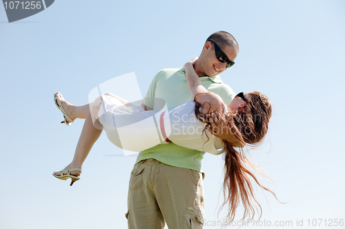 Image of Young Guy Carrying His Girlfriend In His Arms