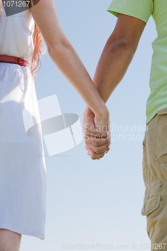 Image of young couple holding hands