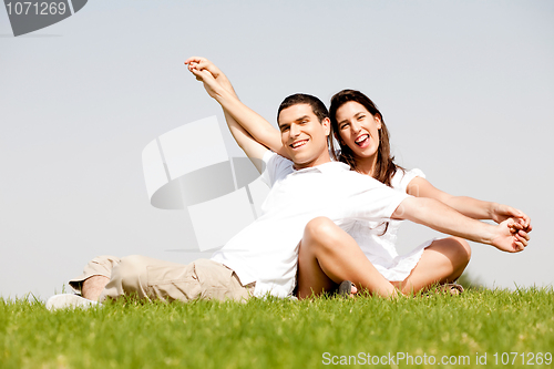 Image of Young Couple Sitting Together Outside