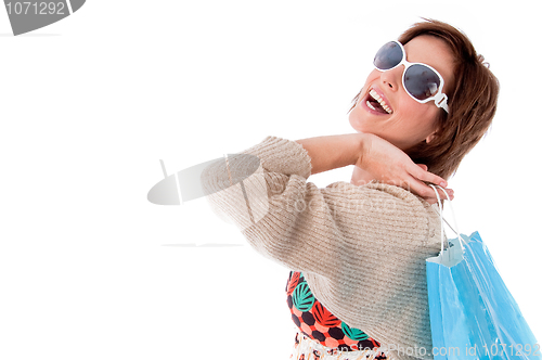 Image of Happy young woman with shopping bags on white