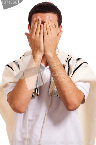 Image of jewish man closing face with his hands while praying
