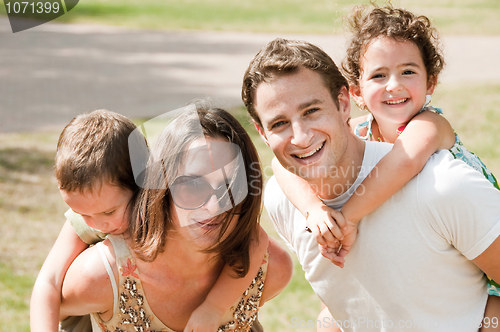 Image of parents biggyback their children