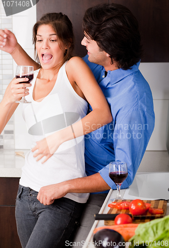 Image of playful young couple enjoying their love in kitchen