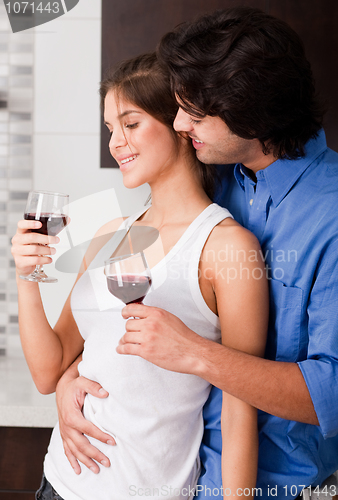 Image of adult male and female tosting at kitchen
