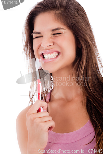 Image of pretty young women closing her eyes while  brussing her teeh