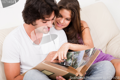 Image of closeup of beautiful young women showing blank board and smiling