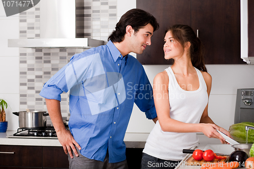Image of couple starring each other eyes in the kitchen