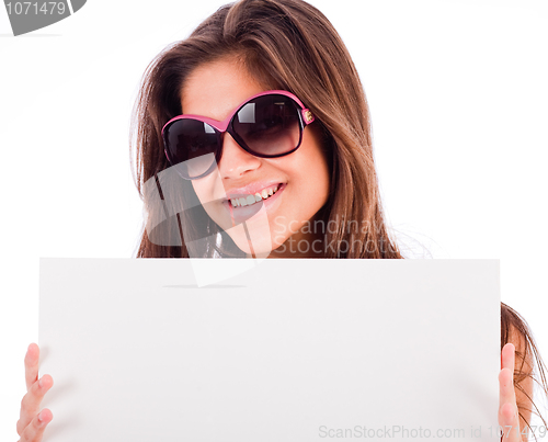 Image of closeup of beautiful young women showing blank board and smiling