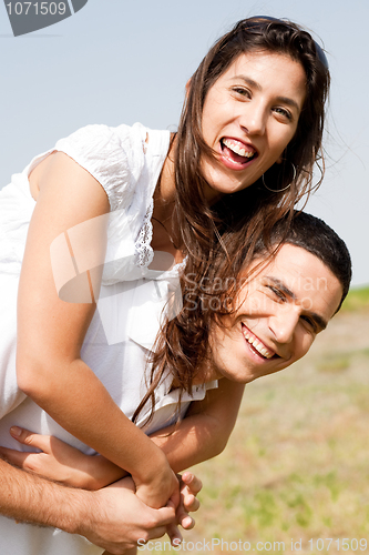 Image of Smiling young couple piggybacking