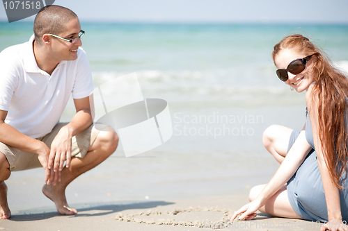 Image of Young loving Couple siting on the beach