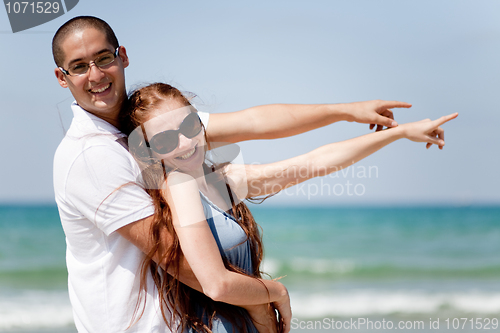 Image of Couple smiling and pointing at the sea