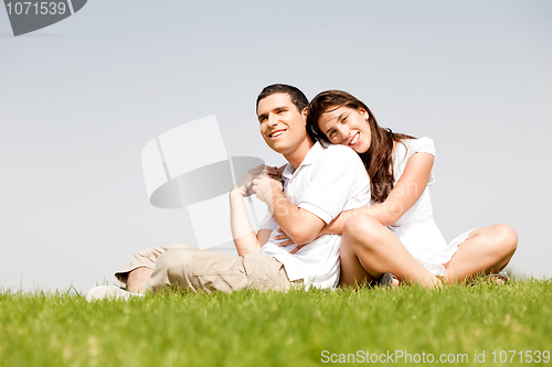 Image of Happy young women with arms around her husband and laying on his shoulder