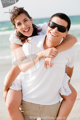 Image of Young man piggyback his girlfriend