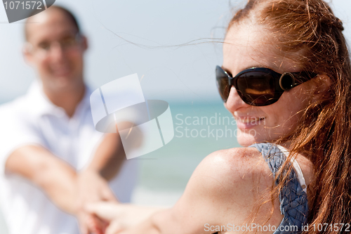 Image of Rear view of young couple sitting at the lbeach