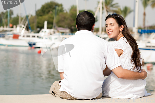 Image of Rear view of young couple sitting at the harbour