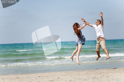 Image of Happy young couple having fun on the beach