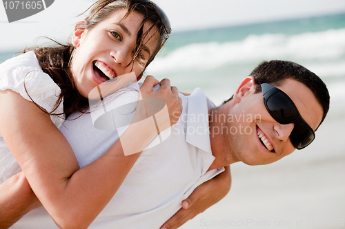 Image of Playful young couple smiling on the beach