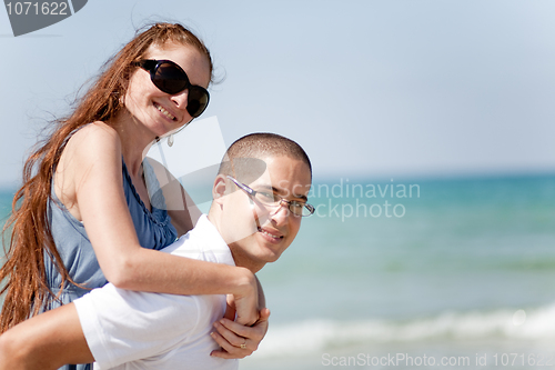 Image of Young man piggyback his girlfriend