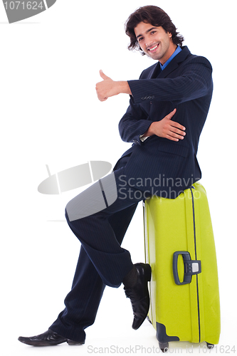 Image of Corporate man sitting above the luggage showing thumbsup