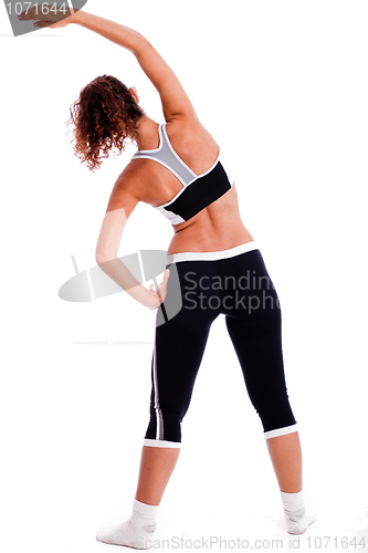 Image of Rear view of a Cute fitness girl stretching her body