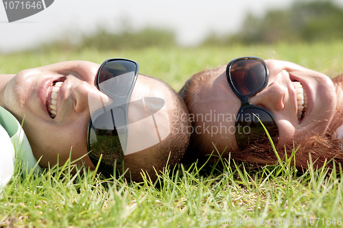 Image of Happy young couple smiling on a lawn