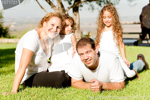 Image of Family of four lying in grass