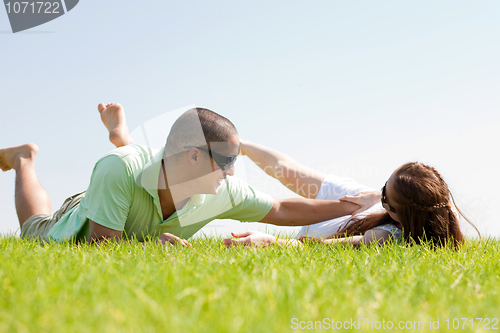 Image of Young man playing with his wife on a grass