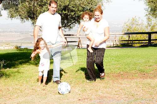 Image of Parents and kids playing football