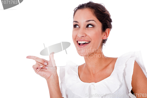 Image of Close up portrait of a happy young woman pointing up at copyspace