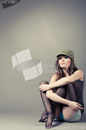 Image of Beautiful young girl sitting with her knees pulled up