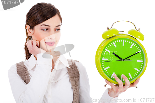 Image of young beautiful brunette holding the clock and seeing