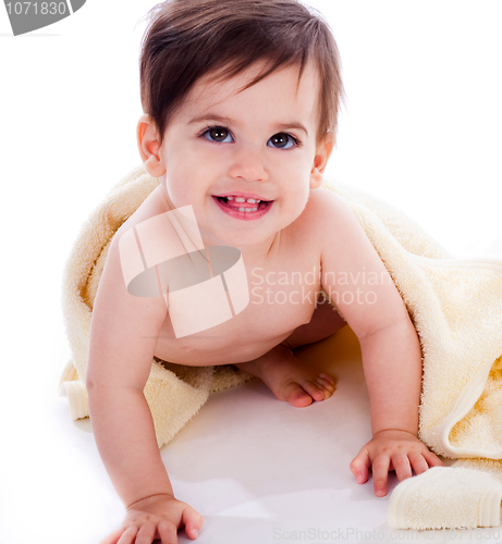 Image of Baby showing its teeth under yellow towel