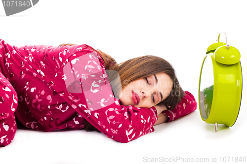 Image of Pretty women sleeping with the alarm beside her