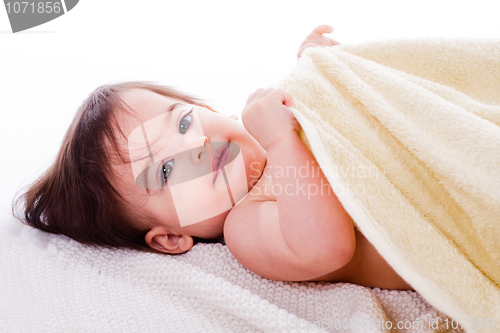Image of Little baby lying in white towel and wrapped with yellow towel